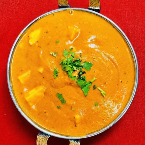 Masala & Curry's Indian paneer butter masala, garnished with fresh cilantro, in a metal bowl.